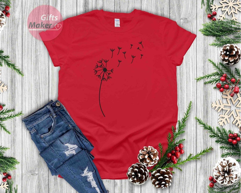 May include: A red t-shirt with a black dandelion graphic. The dandelion has seeds blowing in the wind.