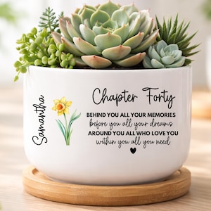 May include: A white ceramic mug with a black handle and the text "But first, coffee" in a black, handwritten-style font. The mug is on a white surface.