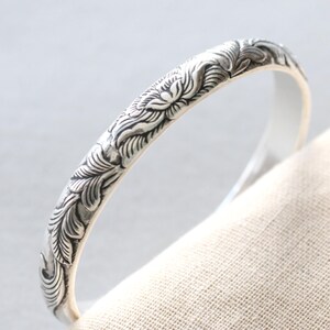 this 999 pure silver cuff bracelet is engraved with a beautiful peony design, symbolizing strength. Its open-ended, adjustable fit ensures comfort and elegance for any wrist size. You can make it even more meaningful by customizing the engraving with a personal message, name, or special date. This bracelet is a perfect gift for mothers, wives, and daughters, and the custom engraving option allows you to create a truly unique piece for occasions like Mother’s Day, birthdays, or anniversaries.