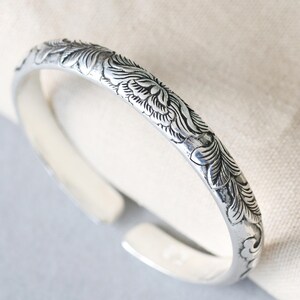 Crafted with care from 999 sterling silver, this cuff bracelet showcases a hand-engraved peony design that radiates beauty and strength. The open-ended design offers an adjustable fit, making it suitable for any wrist size. You can personalize it with your choice of engraving, adding a name, date, or special message that holds sentimental value. This customizable bracelet makes the perfect gift for Mother’s Day, birthdays, or anniversaries, and will be treasured for years to come.