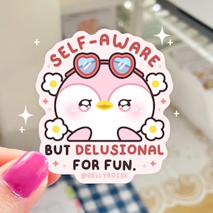 Puede incluir: Un ping&uuml;ino rosa con gafas de sol en forma de coraz&oacute;n y una margarita blanca en la cabeza. El texto "SELF-AWARE BUT DELUSIONAL FOR FUN." est&aacute; debajo del ping&uuml;ino. El texto "@GELLYROISE" est&aacute; debajo del texto.
