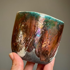Vaso/Recipiente/Yunomi decorativo quadrado, feito à mão em cerâmica com esmalte craquelado branco e detalhes em verde metálico e cobre, com aproximadamente 8 cm x 7 cm.