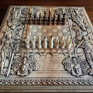Op de afbeelding: Een houten schaakbord met ingewikkelde houtsnijwerk van ridders en andere figuren. Het bord is gemaakt van licht hout en heeft een donkerbruine vlek. De schaakstukken zijn gemaakt van wit en bruin hout en zijn gerangschikt in hun startposities.