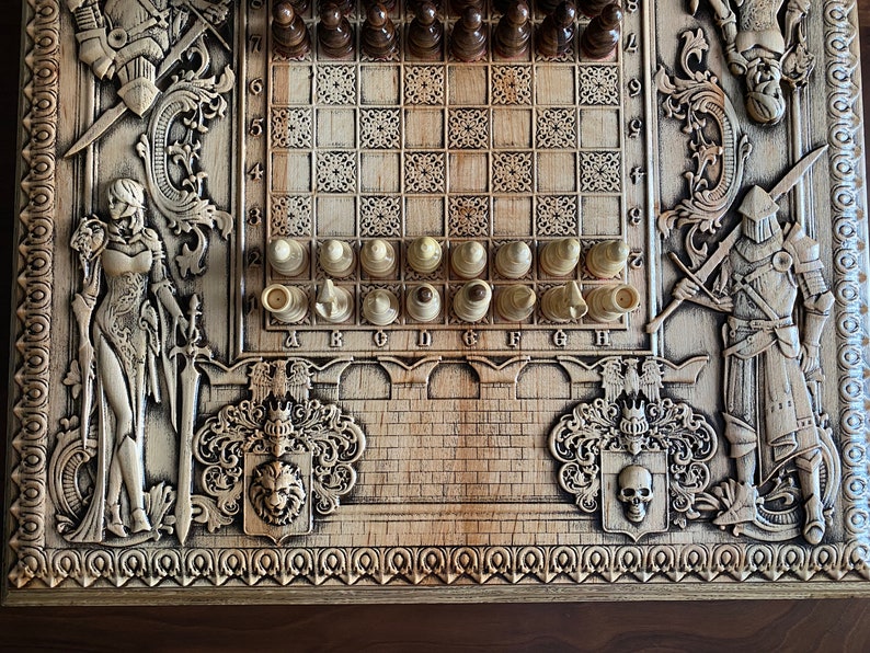 Op de afbeelding: Een houten schaakbord met ingewikkelde houtsnijwerk van ridders, een vrouw met een zwaard en een leeuw. Het bord heeft een lichtbruine afwerking en een traditioneel schaakbordpatroon. De schaakstukken zijn in de beginpositie geplaatst.