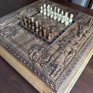 K&ouml;nnte beinhalten: Ein detailliertes Schachspiel aus Holz mit aufwendig geschnitzten Figuren und einem passenden Brett. Das Brett hat ein dunkles Raster zum Spielen und aufwendige Reliefs von Rittern, Schilden und mittelalterlichen Bildern. Die Schachfiguren sind in Elfenbein und Dunkelbraun.