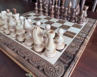 May include: A wooden chess set with intricately carved details on the board. The pieces are made of light wood and are arranged on a dark wood board.