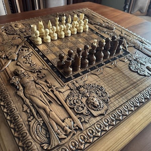K&ouml;nnte beinhalten: Ein detailliertes Schachspiel aus Holz mit aufwendig geschnitzten Figuren und einem Brett. Das Brett hat ein Raster zum Spielen mit hellen und dunklen Feldern. Das Set enth&auml;lt helle und dunkle Schachfiguren, bereit f&uuml;r ein Spiel.