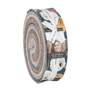 May include: A rolled bundle of fabric strips, featuring a floral pattern in shades of blue, red, and yellow. The fabric is tied with a white ribbon that has the brand name "moda fabrics + supplies" printed on it. The fabric roll is on a white background.