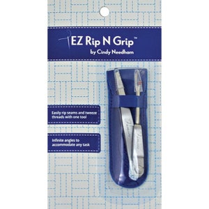 May include: A blue leather case with a silver seam ripper and tweezers inside. The case has the text "EZ Rip N Grip" and "by Cindy Needham" on the front. The text "Famore" is printed on the tools.