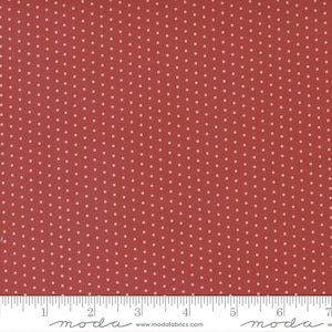 May include: Red fabric with a white polka dot pattern. The fabric is shown with a ruler, with the text "moda" printed on the ruler.