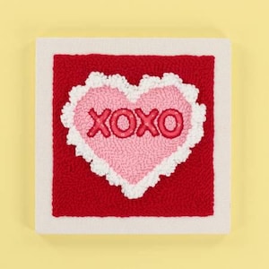 May include: A white canvas with a red background and a pink heart with white trim. The heart has the word "XOXO" in red letters.