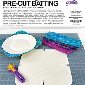 May include: A craft kit for making plate cozies. The kit includes pre-cut 100% cotton microwavable batting, fabric, and instructions. The image shows a plate cozy with a plate inside, fabric squares, and a rotary cutter. The text reads "Plate Cozy PRE-CUT BATTING".