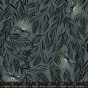 May include: A dark gray fabric featuring a repeating pattern of black willow-like leaves and white fireflies with gold radiating light rays. A black selvage edge at the bottom displays the text Ruby Star Society and a 7-inch ruler.