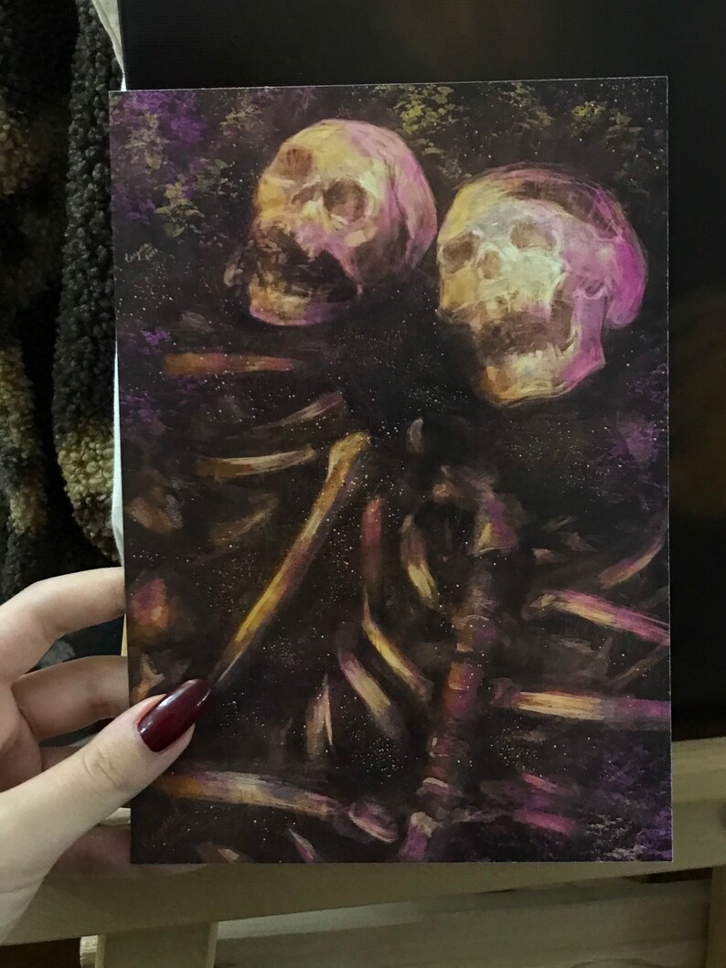 Puede incluir: Una pintura de dos cr&aacute;neos humanos con una figura esquel&eacute;tica en el fondo. Los cr&aacute;neos est&aacute;n pintados en tonos de rosa y amarillo, y la figura esquel&eacute;tica est&aacute; pintada en tonos de marr&oacute;n y dorado. El fondo es de color morado oscuro.