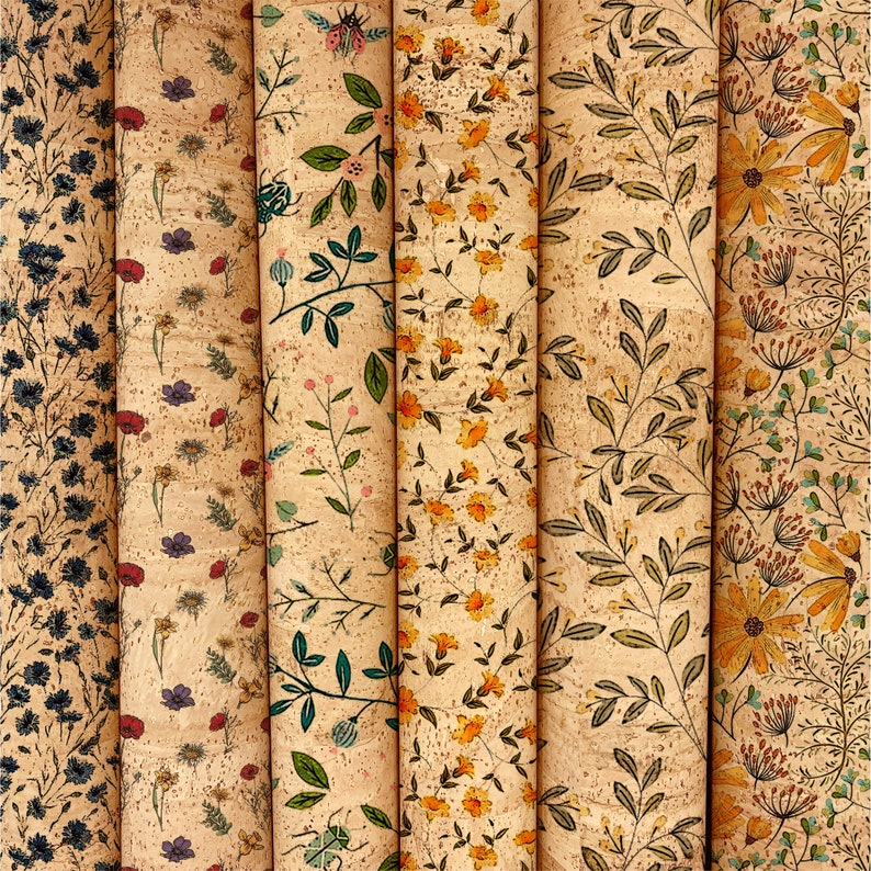 May include: A collection of rolled cork fabric featuring various floral patterns. The designs include blue, red, purple, and yellow flowers, along with green leaves, all set against a natural cork background. The rolls are arranged vertically, showcasing the diverse botanical prints.