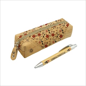 Puede incluir: Un estuche para lápices de corcho con un patrón floral y un cierre de cremallera. El estuche es marrón con flores rojas, rosas y amarillas. El estuche viene acompañado de un bolígrafo plateado con un cuerpo de corcho y el texto "LISBOA-PORTUGAL" impreso en él.