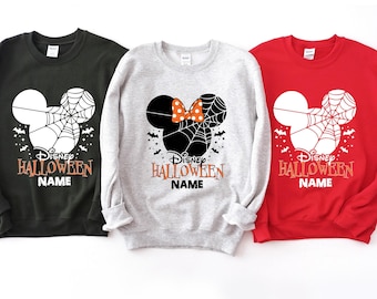 May include: Three sweatshirts with a Disney Halloween design. The sweatshirts are black, gray, and red. Each sweatshirt features a Mickey Mouse head with a spiderweb and the text "Disney Halloween Name".