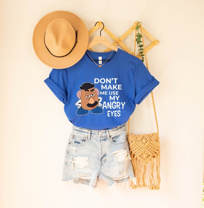 Może przedstawiać: Koszulka w kolorze kr&oacute;lewskiego błękitu z białym nadrukiem przedstawiającym Pana Ziemniaka z tekstem "Nie zmuszaj mnie do używania moich złych oczu".