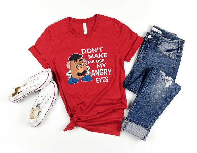 Może przedstawiać: Czerwona koszulka z kresk&oacute;wkowym wizerunkiem Pana Potato Head i tekstem "Nie zmuszaj mnie do używania moich złych oczu".