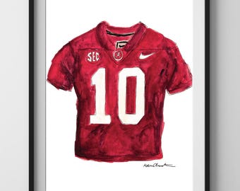 May include: A watercolor painting of a red football jersey with the number 10 on the front. The jersey has the SEC logo on the left shoulder and a Nike swoosh on the right shoulder.