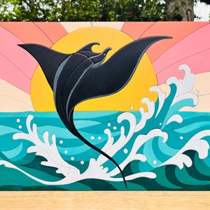 May include: A rectangular wooden wall art piece featuring a black manta ray leaping from turquoise ocean waves. The background displays a yellow sun set against a pink and peach-colored sky with radiating sunbeams, creating a layered, multi-colored scene.