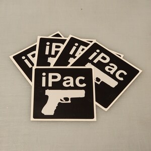 May include: A stack of black and white stickers with the text "iPac" and a silhouette of a handgun.