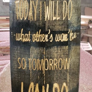 May include: A wooden sign with a motivational quote: "TODAY I WILL DO what other's won't, SO TOMORROW I CAN DO WHAT OTHER'S CAN'T". The sign is made from a reclaimed barrel stave and has metal bands with brass rivets.