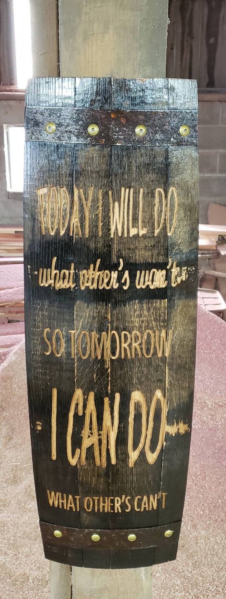 May include: A wooden sign with a motivational quote: "TODAY I WILL DO what other's won't, SO TOMORROW I CAN DO WHAT OTHER'S CAN'T". The sign is made from a reclaimed barrel stave and has metal bands with brass rivets.
