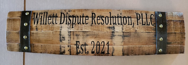 May include: A wooden sign with metal accents and the text "Willett Dispute Resolution, PLLC Est. 2021" in black lettering.