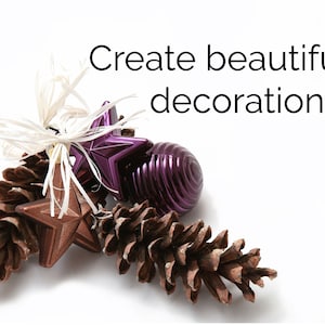 May include: Create beautiful decorations. A close-up of a brown pine cone, a purple star ornament, a brown star ornament, and a purple round ornament.