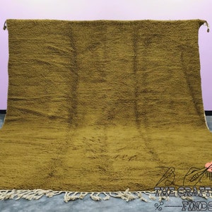 May include: A large, mustard yellow, handwoven rug with a fringe border. The rug is made of wool and has a soft, textured surface.