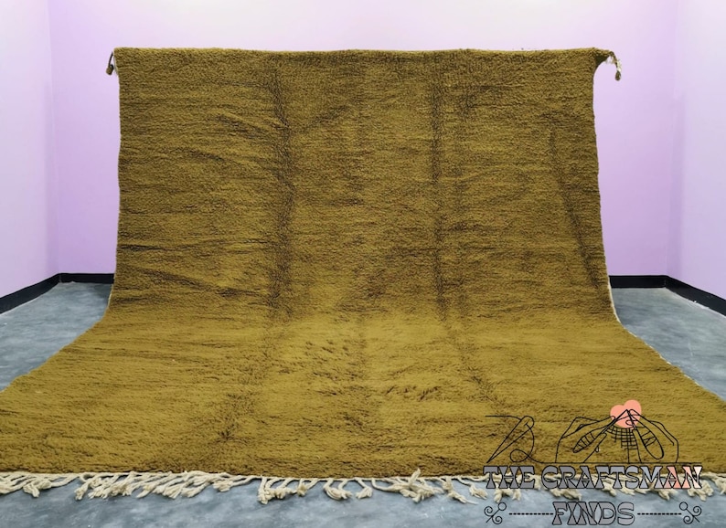 May include: A large, mustard yellow, handwoven rug with a fringe border. The rug is made of wool and has a soft, textured surface.