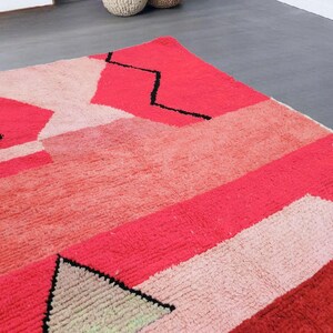 Puede incluir: Una vibrante alfombra geom&eacute;trica con una mezcla de tonos rosas y rojos con l&iacute;neas negras de acento. El dise&ntilde;o de la alfombra incorpora varias formas y sombras, creando un patr&oacute;n moderno y llamativo. La alfombra est&aacute; hecha de un material suave y texturizado.