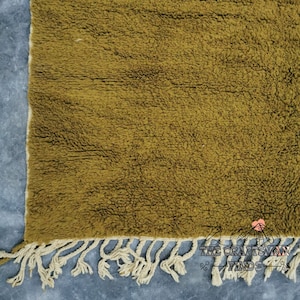 May include: A mustard yellow rug with a fringe border. The rug is made of a soft, fluffy material.