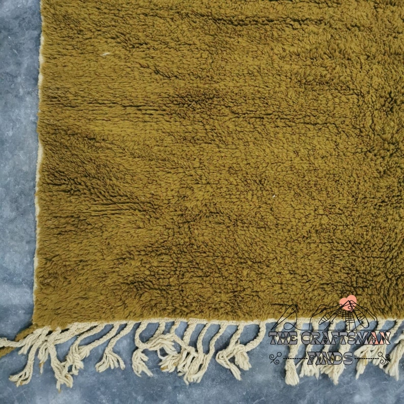 May include: A mustard yellow rug with a fringe border. The rug is made of a soft, fluffy material.