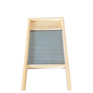 Op de afbeelding: Een houten wasbord met een gegolfd metalen oppervlak. Het wasbord heeft twee houten poten.