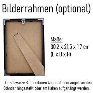May include: A black picture frame with a cardboard backing and a wooden stand. The frame measures 30.2 x 21.5 x 1.7 cm. Text on the image says the frame can be displayed with the stand or hung.