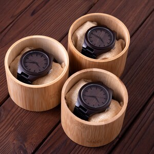 Pu&ograve; includere: Tre orologi da polso in legno in scatole individuali di bamb&ugrave;. Ogni orologio ha un quadrante e un cinturino in legno marrone scuro.