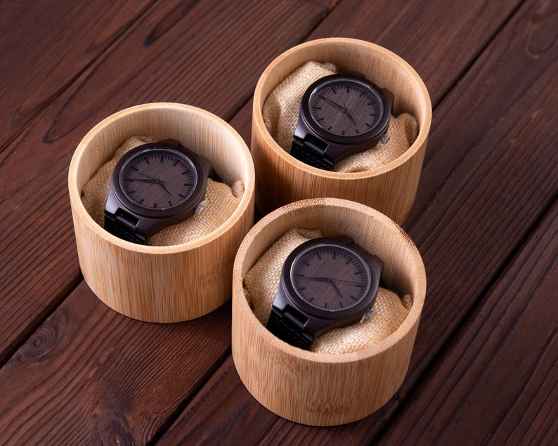 Pu&ograve; includere: Tre orologi da polso in legno in scatole individuali di bamb&ugrave;. Ogni orologio ha un quadrante e un cinturino in legno marrone scuro.