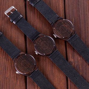 Pu&ograve; includere: Tre orologi da polso in legno con cinturini in pelle nera. Gli orologi hanno diverse incisioni sul quadrante, tra cui "Groom", "Best Man" e "Groomsmen".