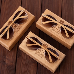 Puede incluir: Cuatro cajas de madera con gafas de sol en su interior. Cada caja tiene un nombre y un t&iacute;tulo diferentes grabados en la parte delantera. Los nombres son Charles, Lucas, Devid, y el t&iacute;tulo es "Best Man", "Groomsme" o "Ev Roo".