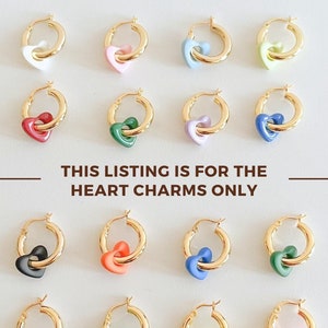 May include: A set of 12 gold hoop earrings with colorful heart charms. The charms are in various colors, including pink, blue, green, yellow, orange, and black.  "THIS LISTING IS FOR THE HEART CHARMS ONLY" is written in brown text on a white background.