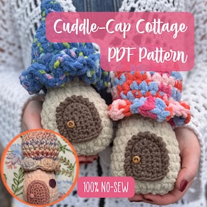 May include: Two crocheted mushroom-shaped houses with beige stems and textured caps in blue and multi-colored yarn. Each features a brown door with a small wooden button. Text reads Cuddle-Cap Cottage PDF Pattern and 100% NO-SEW.