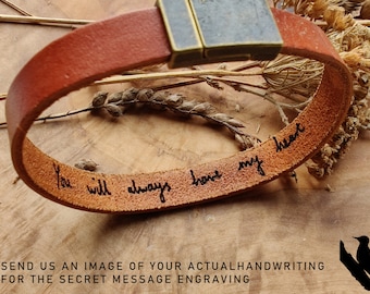 May include: A brown leather bracelet with a metal clasp. The bracelet has a handwritten message that reads "You will always have my heart".