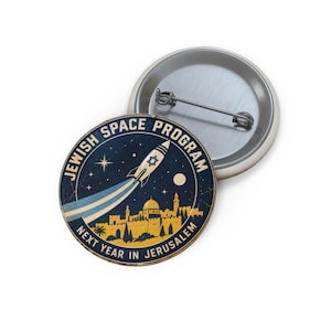 Può includere: Una spilla rotonda con una scena spaziale blu scuro, un razzo con una Stella di David che sorvola una sagoma gialla di Gerusalemme. Il testo riporta JEWISH SPACE PROGRAM e NEXT YEAR IN JERUSALEM in colore bianco.