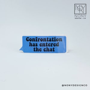 May include: A rectangular sticker with a blue speech bubble design. The text "Confrontation has entered the chat" is printed in black. The sticker is on a white background. The sticker is from NONY Design + Co.