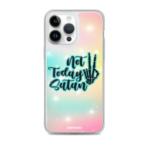 Può includere: Custodia trasparente per telefono con sfondo pastello colorato e la scritta "Not Today Satan" in nero. Il design include un segno di pace a forma di mano di scheletro. La custodia ha un bordo trasparente e un effetto glitterato.