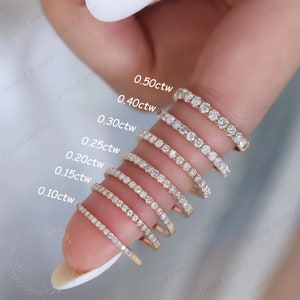 Puede incluir: Un conjunto de nueve anillos de tono dorado con diamantes de diferentes tama&ntilde;os. Los anillos est&aacute;n dispuestos en orden de tama&ntilde;o, con el anillo m&aacute;s peque&ntilde;o en la parte inferior y el anillo m&aacute;s grande en la parte superior. Los anillos est&aacute;n etiquetados con su peso en quilates, que van de 0,10ctw a 0,50ctw.