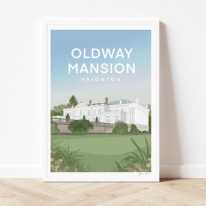 Può includere: Una stampa incorniciata bianca con uno sfondo di cielo azzurro chiaro e un edificio bianco con un prato verde di fronte. Il testo "Oldway Mansion Paignton" è stampato in bianco nella parte superiore della stampa.