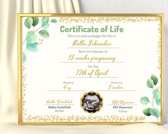 Puede incluir: Un certificado de vida en un marco dorado con hojas de eucalipto verdes y detalles de confeti dorado. Incluye el texto Bella Iskandar, 15 weeks pregnancy, 17th of April, 6 oz, 3 inches, Ridho Fatahilah, Afif Alyamani y una imagen de ecografía.